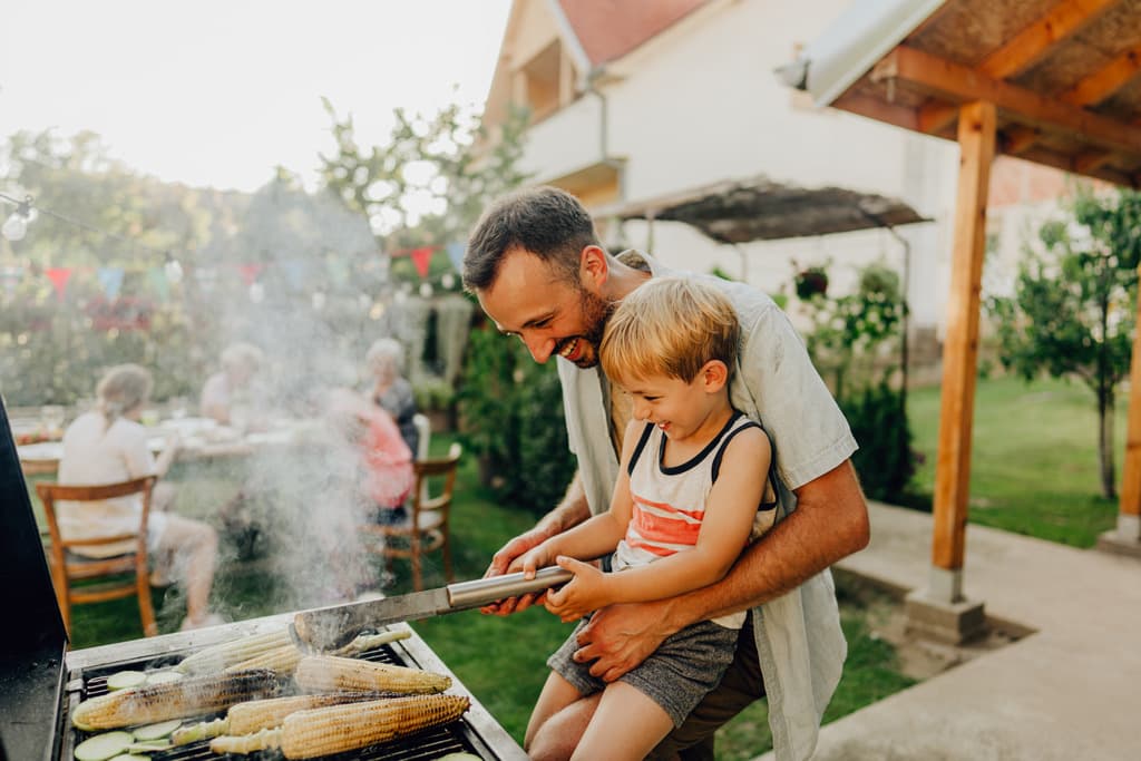 Father and child at backyard BBQ